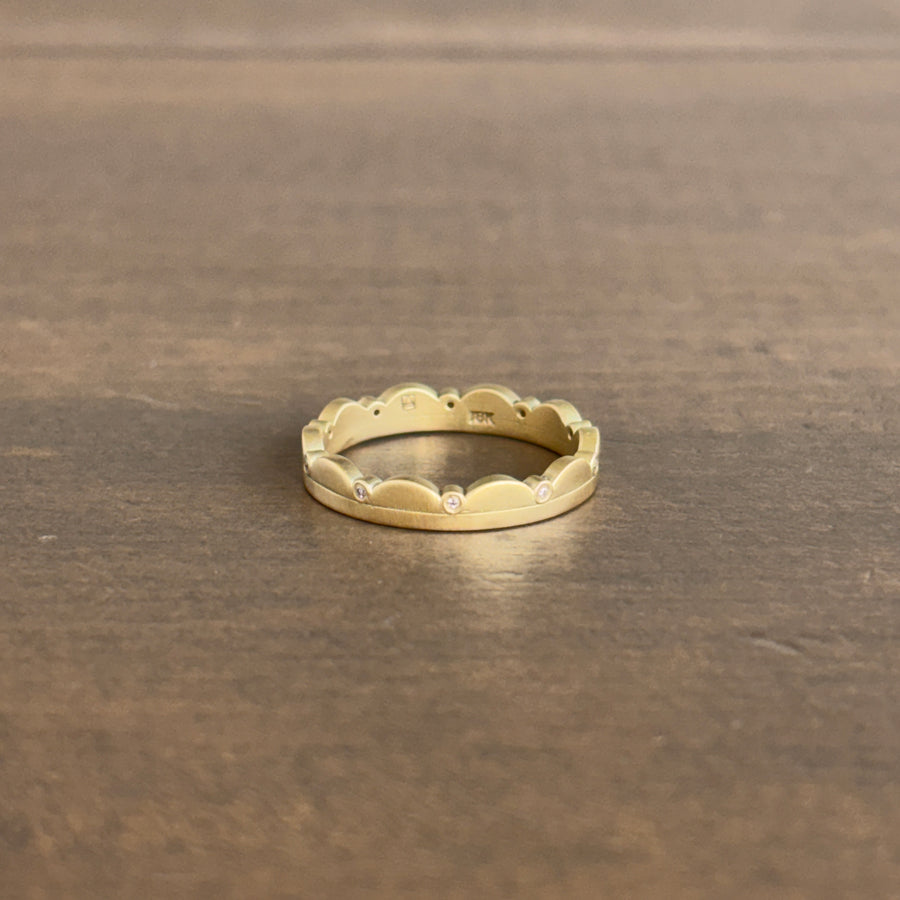 Gold ring with a textured band on a brown surface