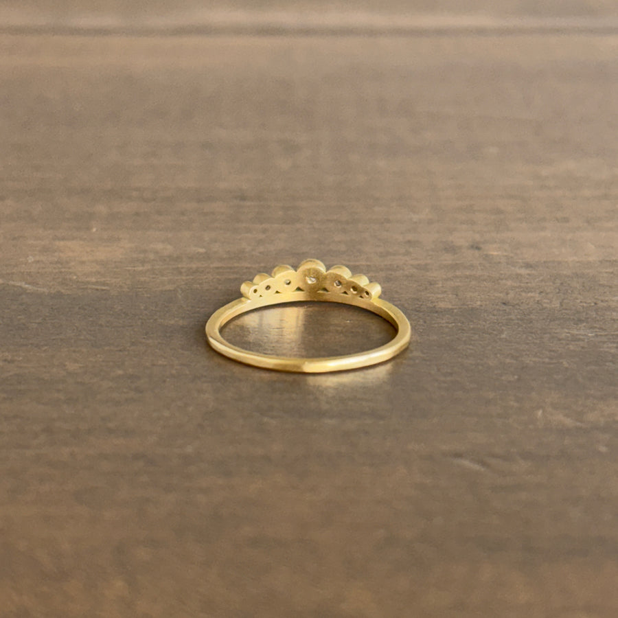 Gold ring with a crown design on a wooden surface