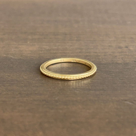 Gold ring on a textured brown surface