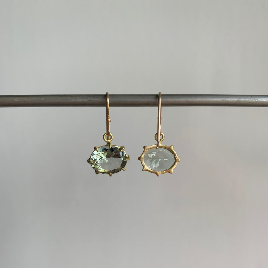 A pair of green amethyst earrings set in yellow gold hanging back view
