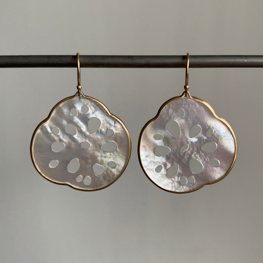 Pair of earrings with textured circular design on a gray background