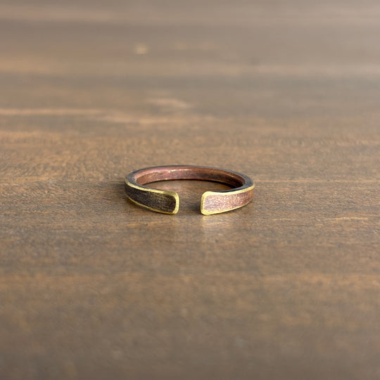brass ring with gold accents on a wooden surface