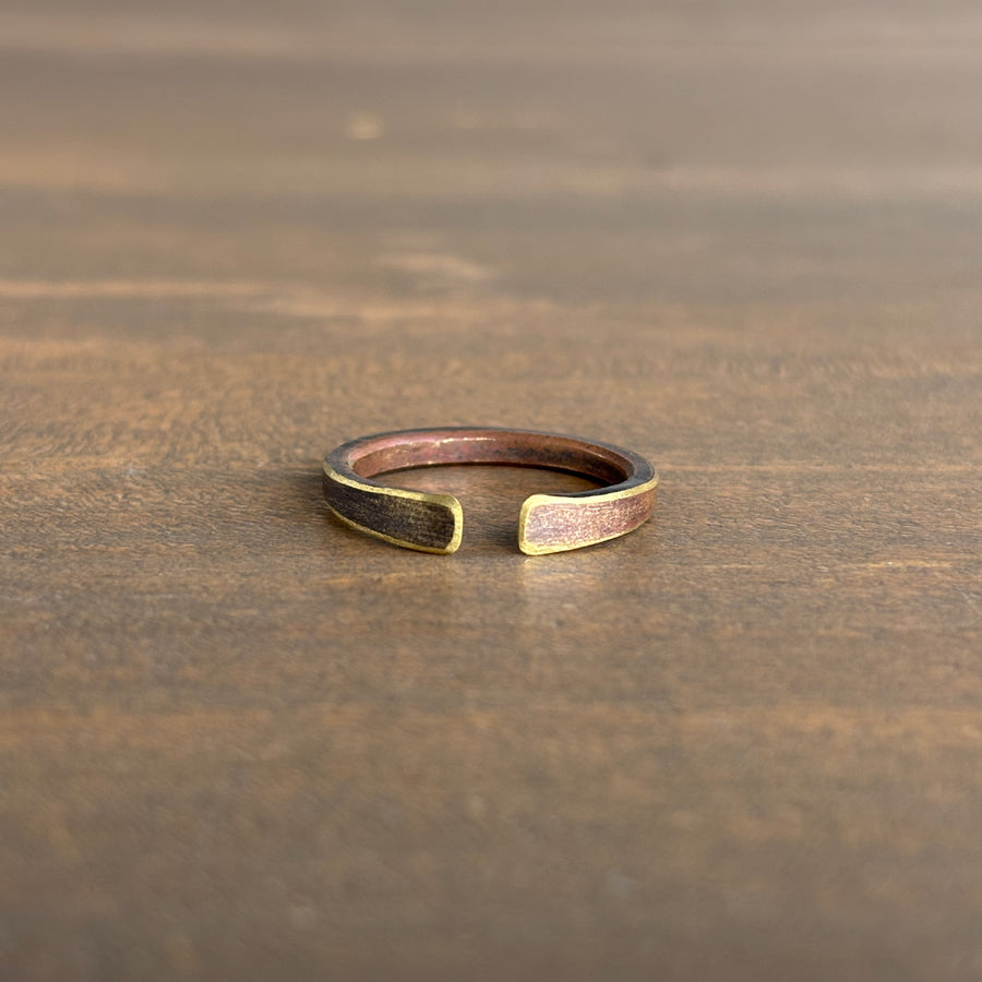brass ring with gold accents on a wooden surface
