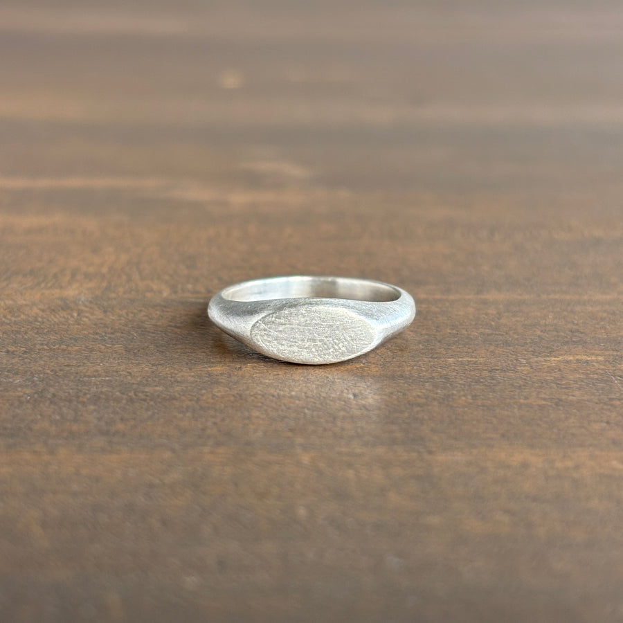 Silver ring on a wooden surface