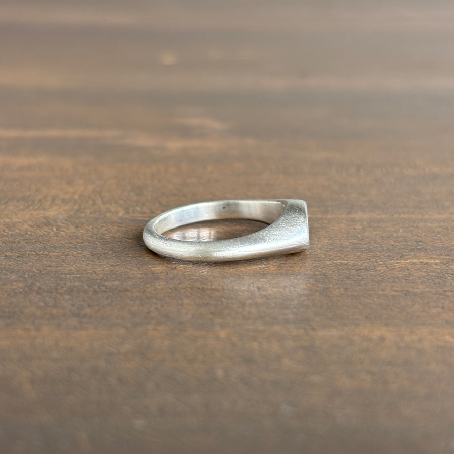 Silver ring on a wooden surface