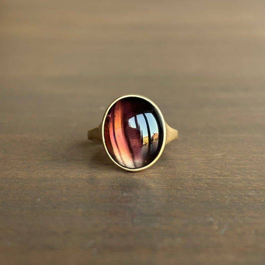 Ring with a colorful stone on a wooden surface
