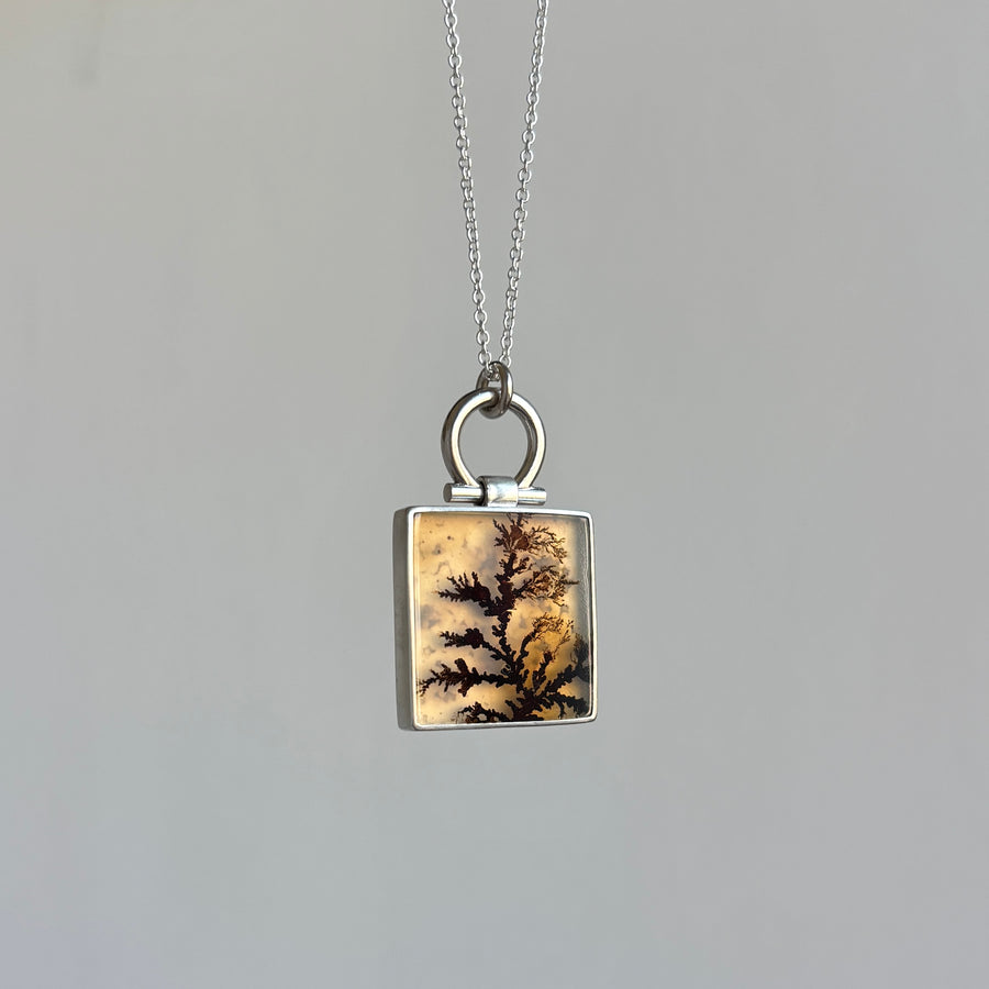 Necklace with a square pendant featuring a natural pattern on a gray background
