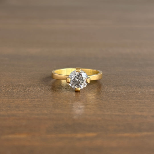 Gold ring with a diamond on a wooden surface