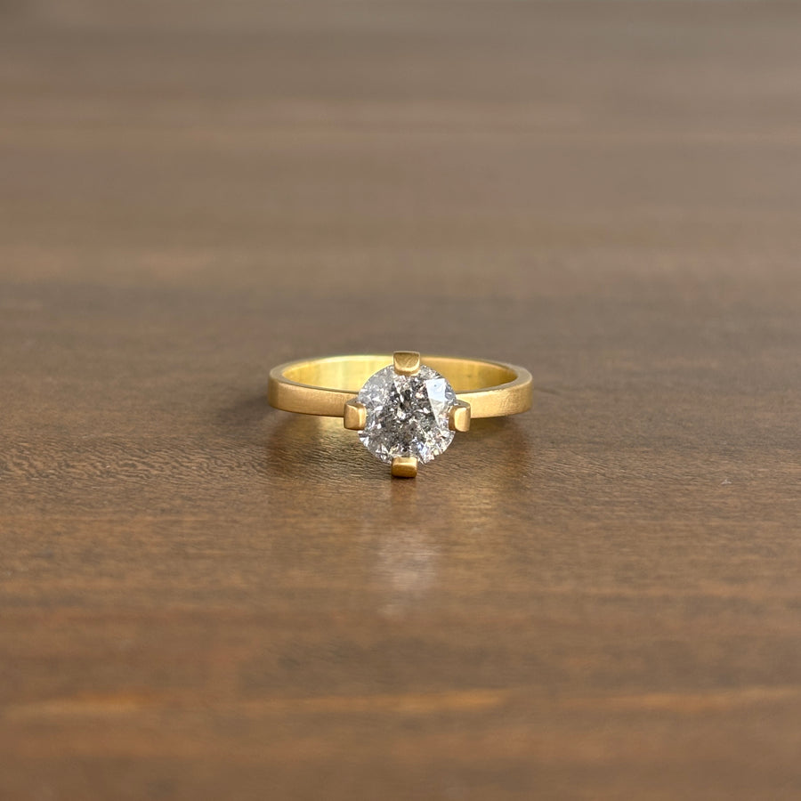 Gold ring with a diamond on a wooden surface