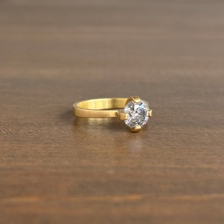 Gold ring with a diamond on a wooden surface