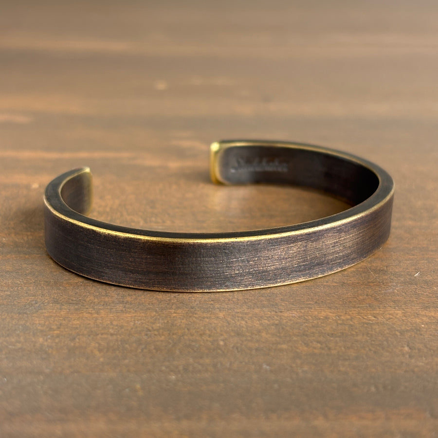 Brass bracelet on a wooden surface