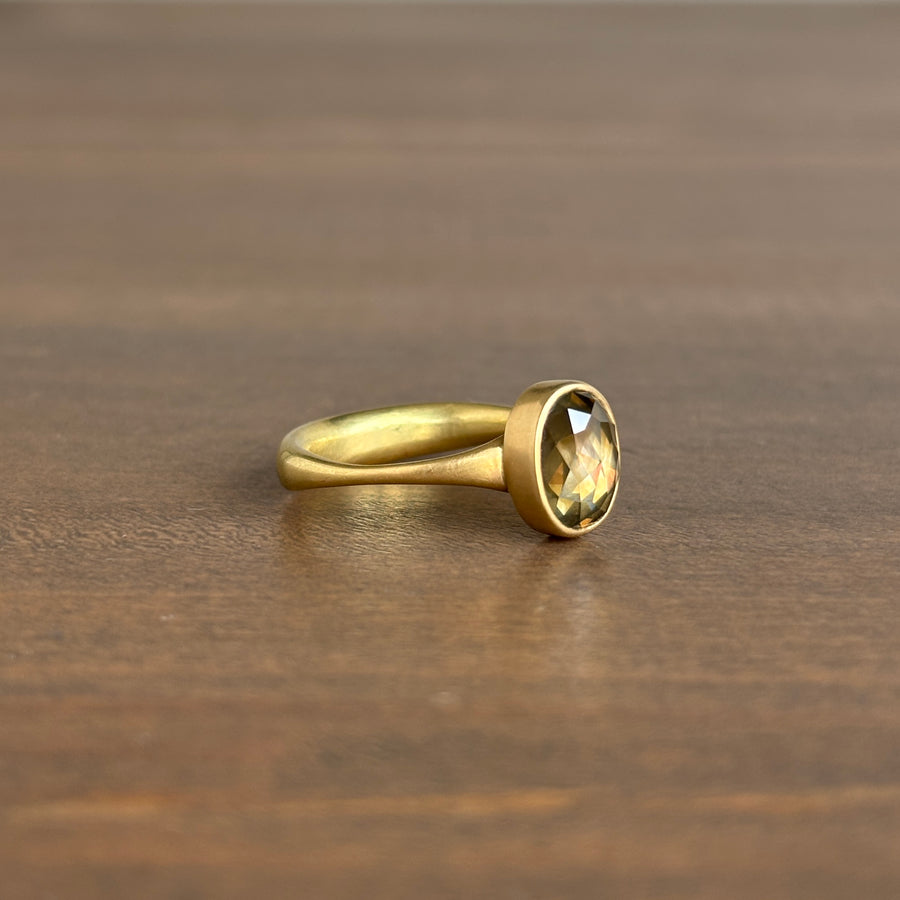 Gold ring with a gemstone on a wooden surface