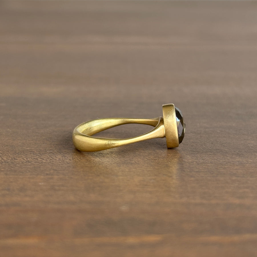 Gold ring with a gemstone on a wooden surface