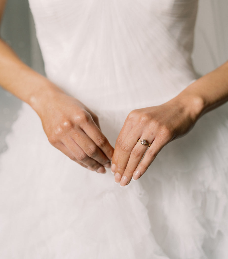 Diamond ring being worn against wedding dress backdrop