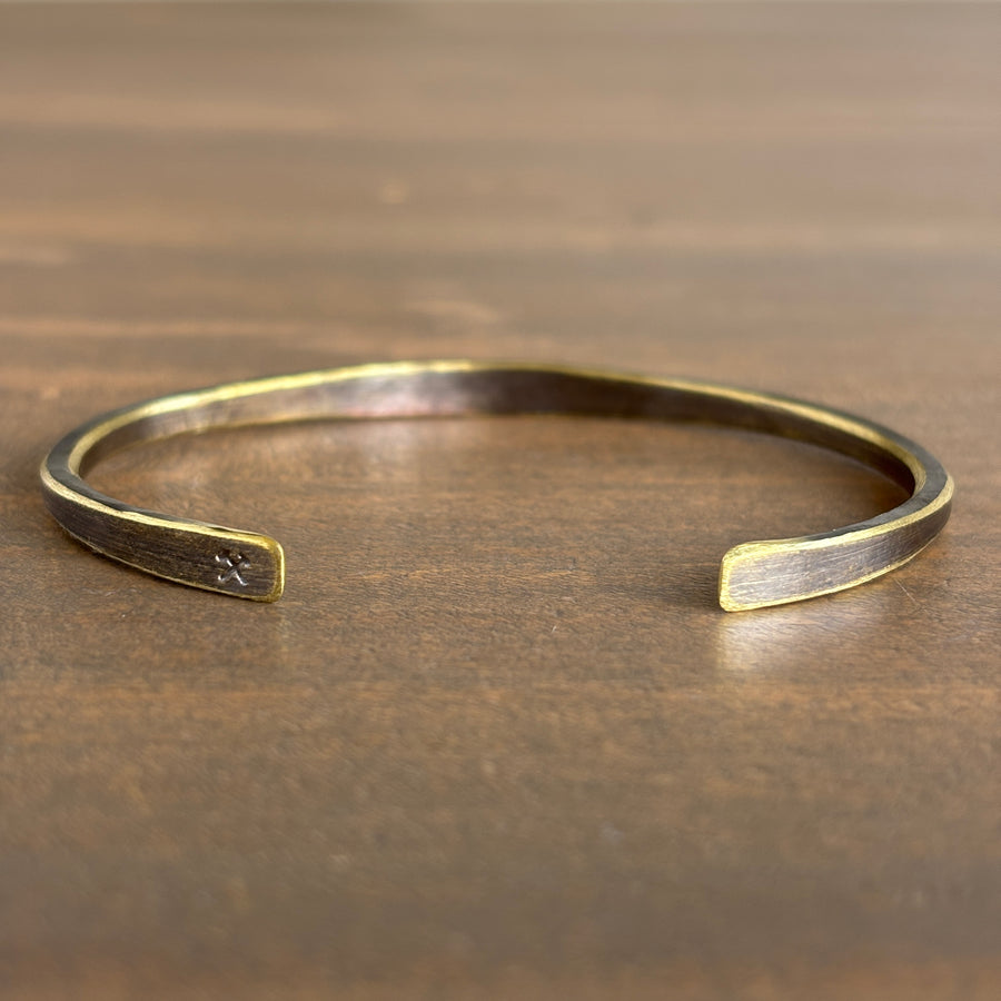 Gold bracelet on a wooden surface