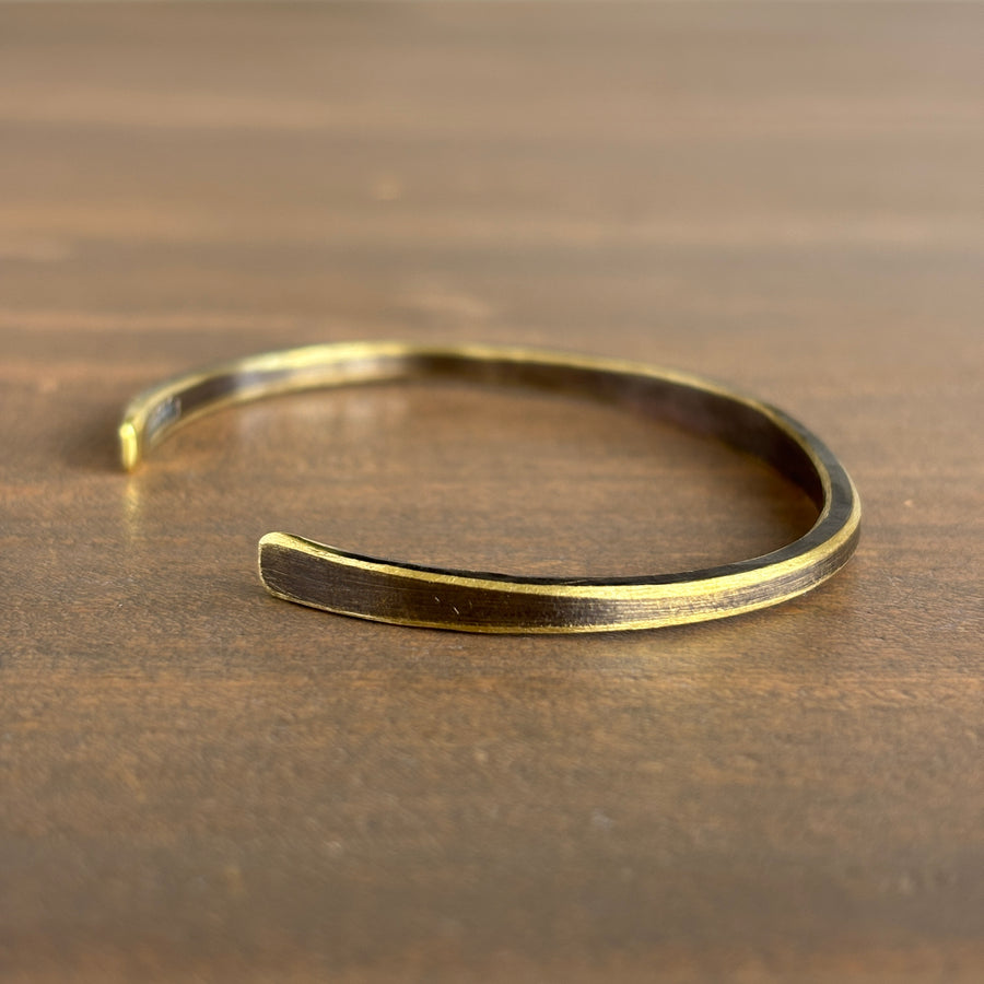 Gold bracelet on a wooden surface