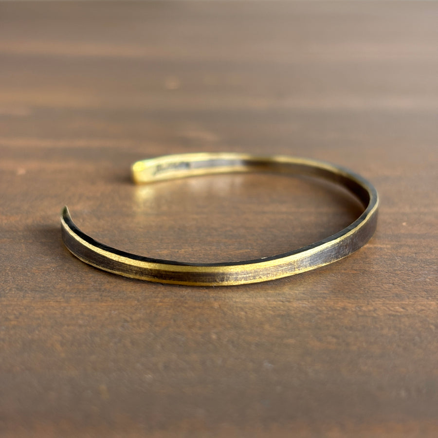 Gold bracelet on a wooden surface