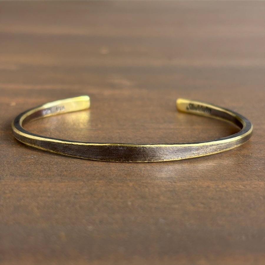 Gold bracelet on a wooden surface