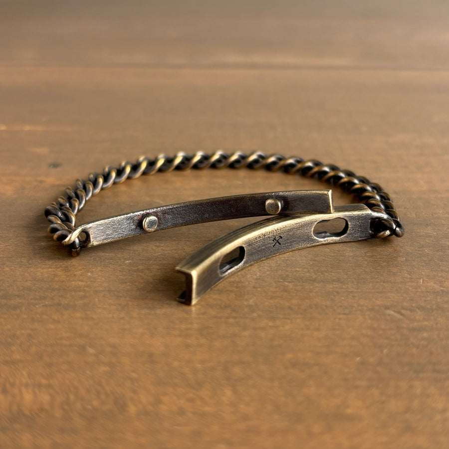 Brass bracelet with chain on a wooden surface