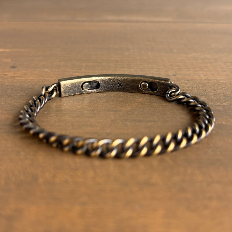 Brass chain bracelet on a wooden surface