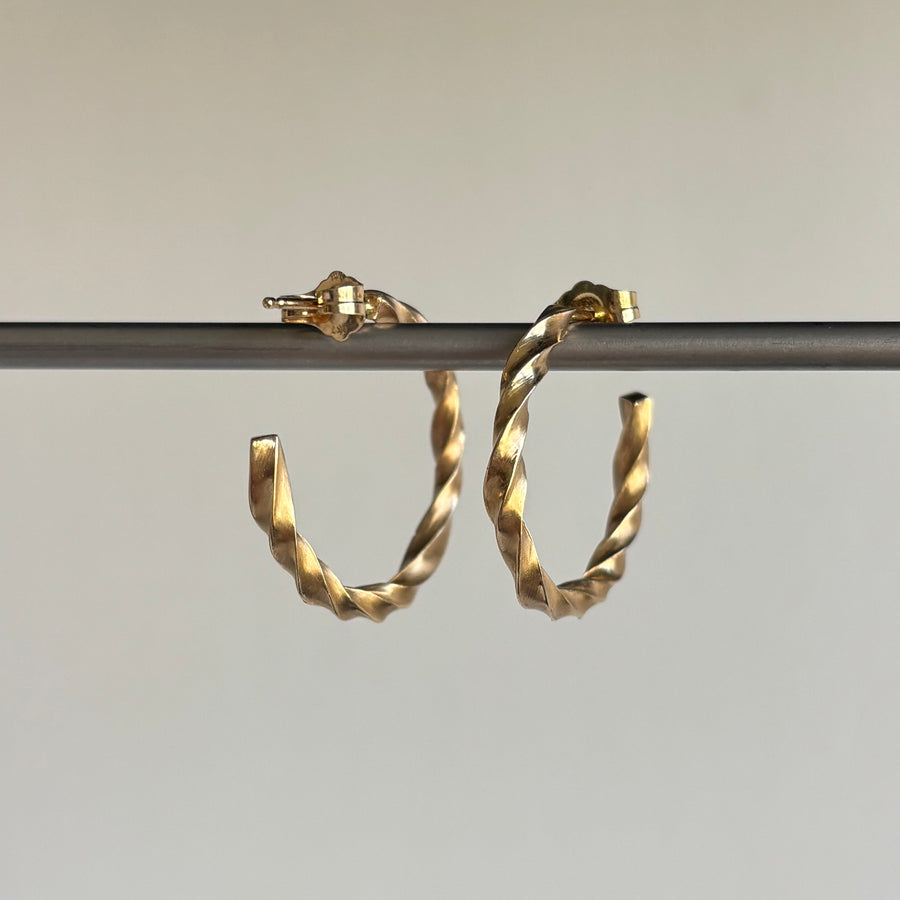 Gold hoop earrings on a gray background