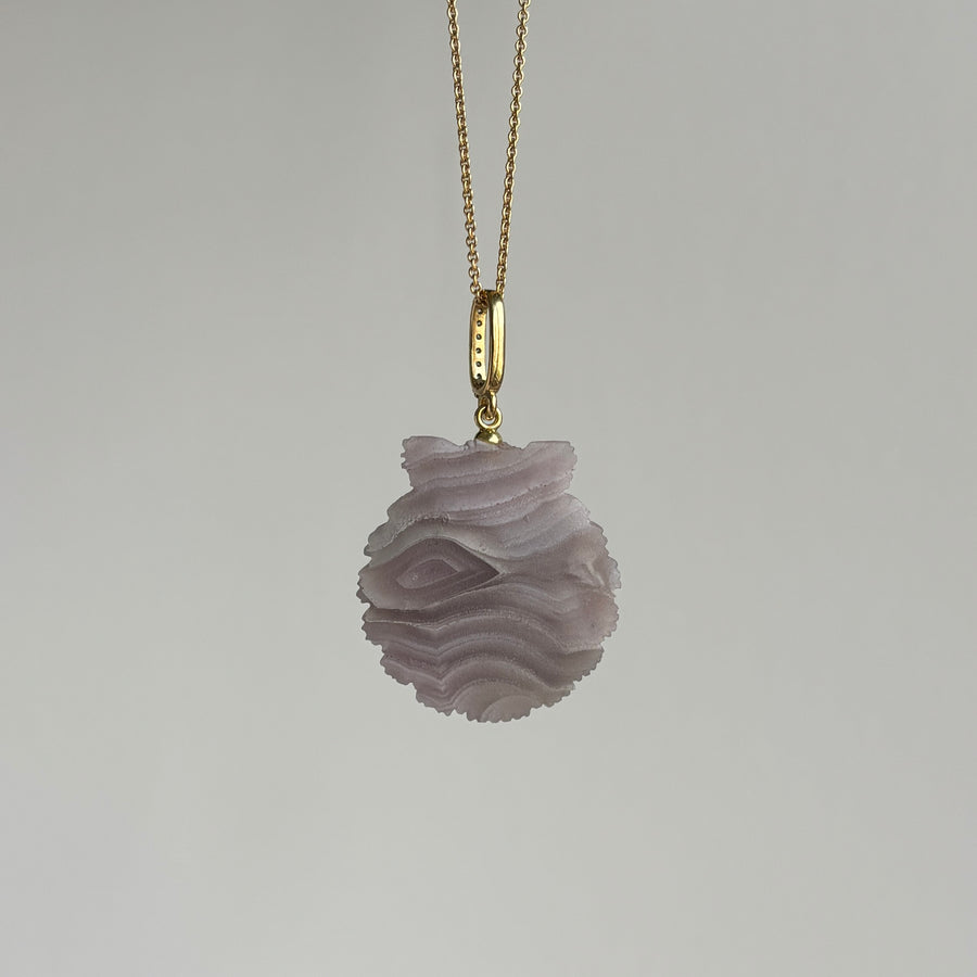 Necklace with a textured pendant on a gray background