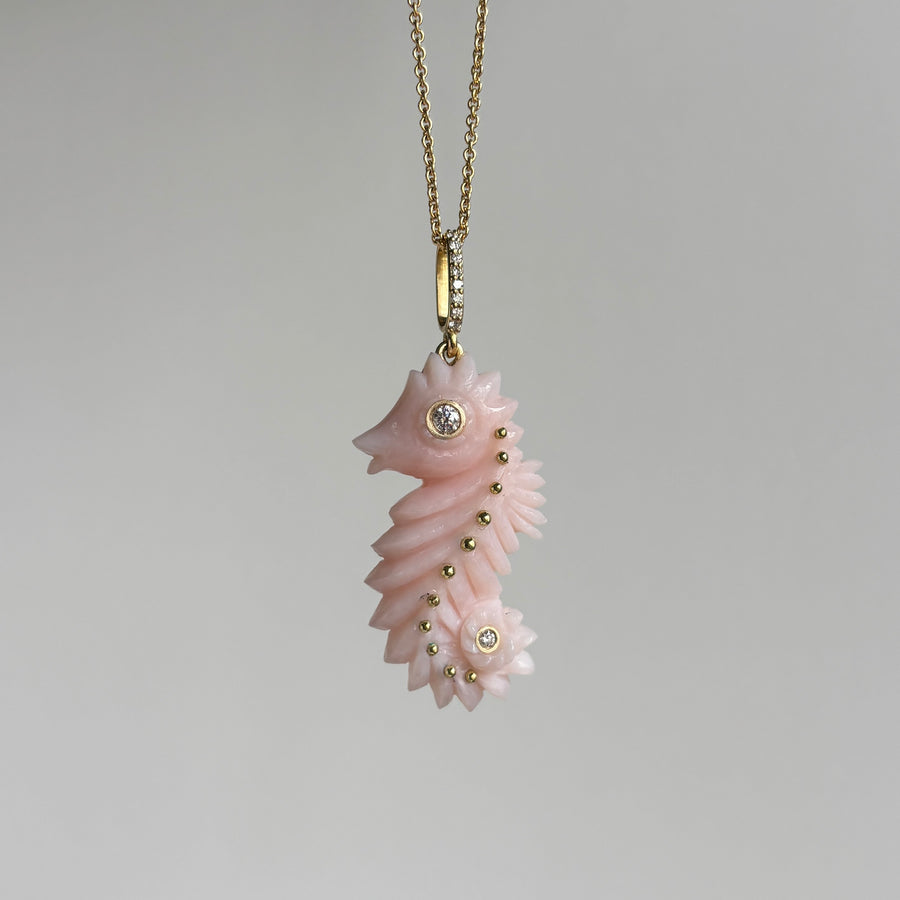 Pink seahorse pendant necklace on a light gray background
