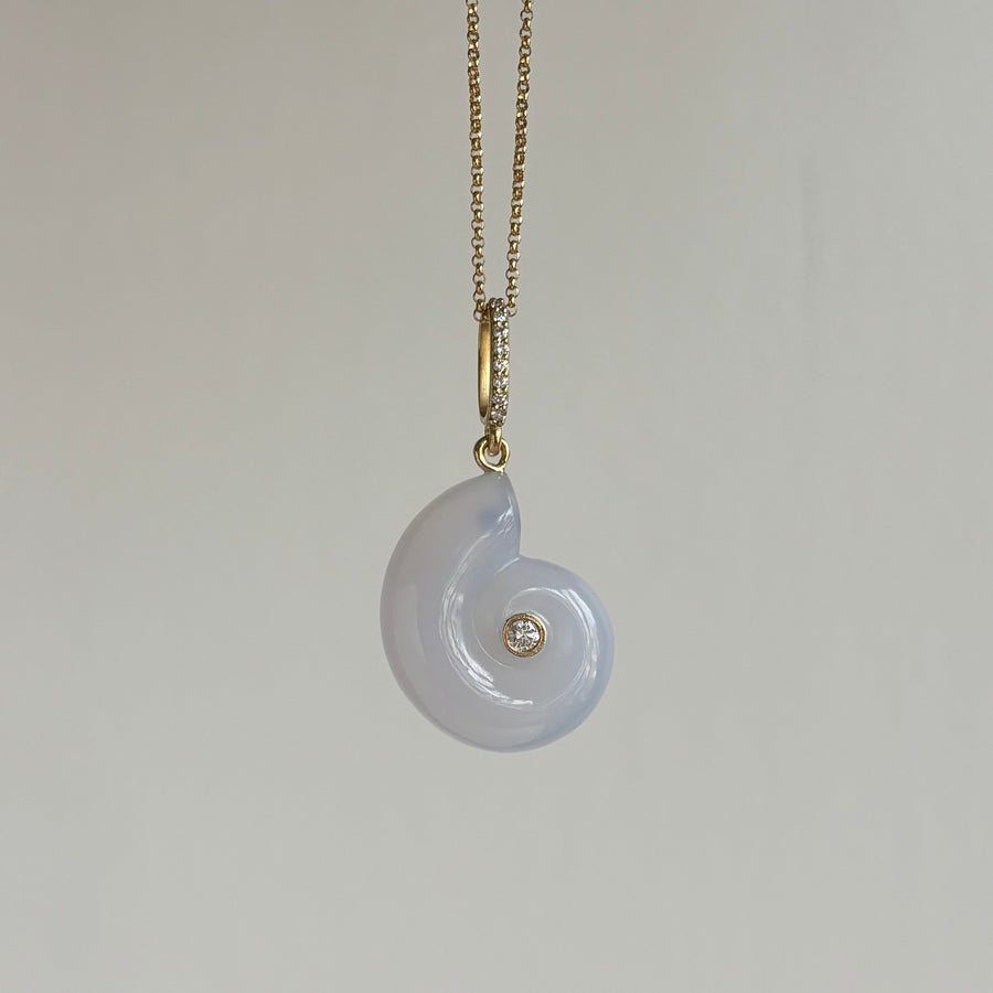 Necklace with a white pendant and gold chain on a light gray background