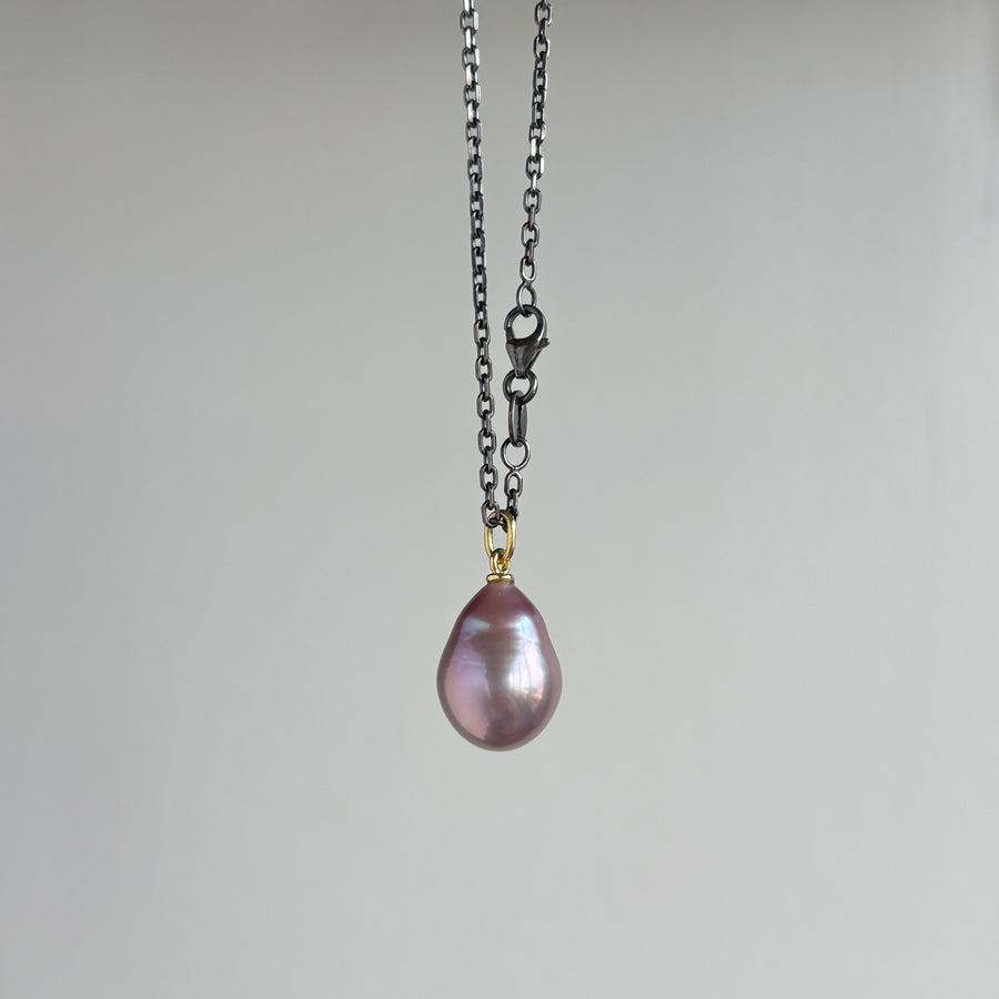 Necklace with a pink teardrop pendant hanging with clasp detail