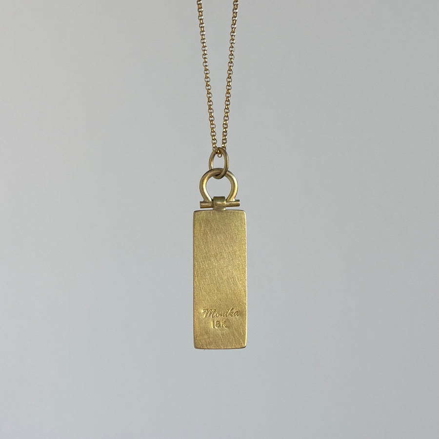 Gold pendant necklace on a gray background