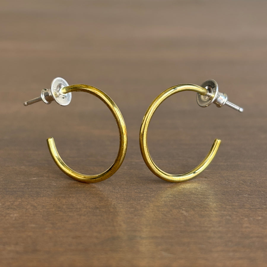 Gold hoop earrings on a wooden surface