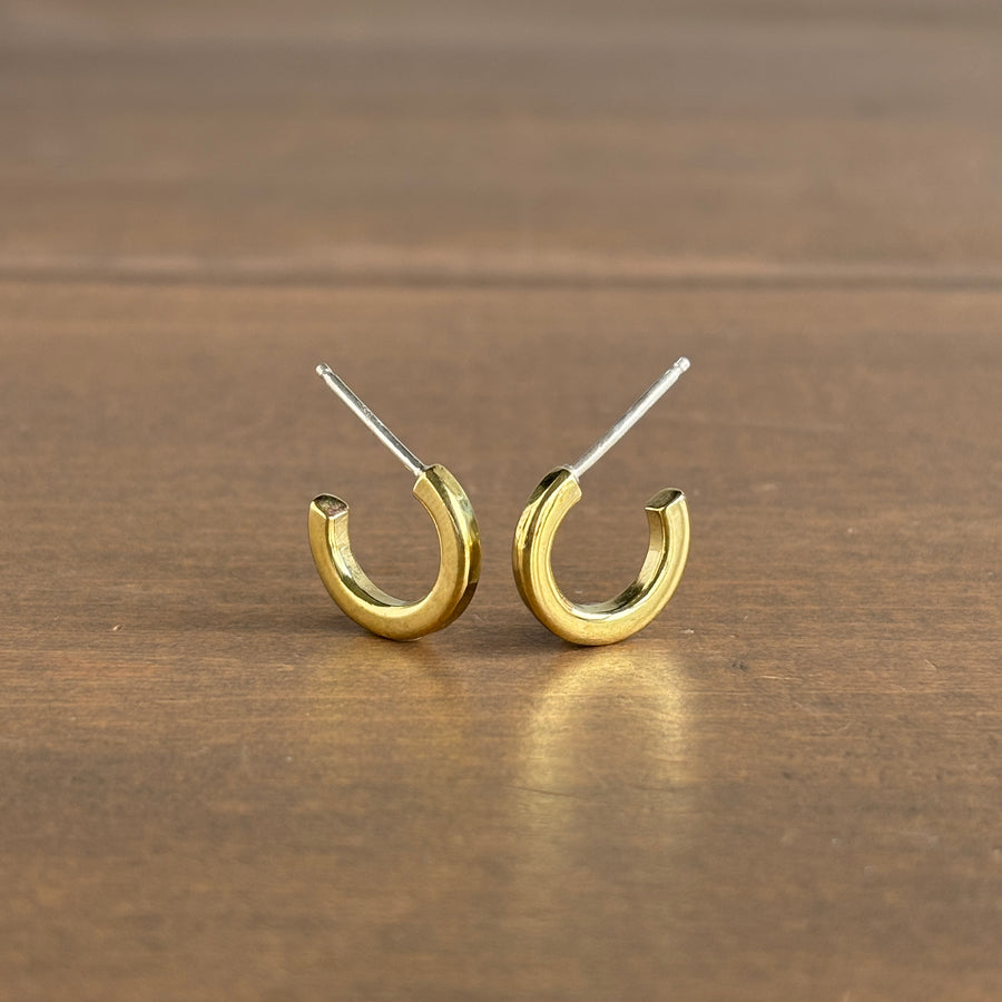 Gold hoop earrings on a wooden surface