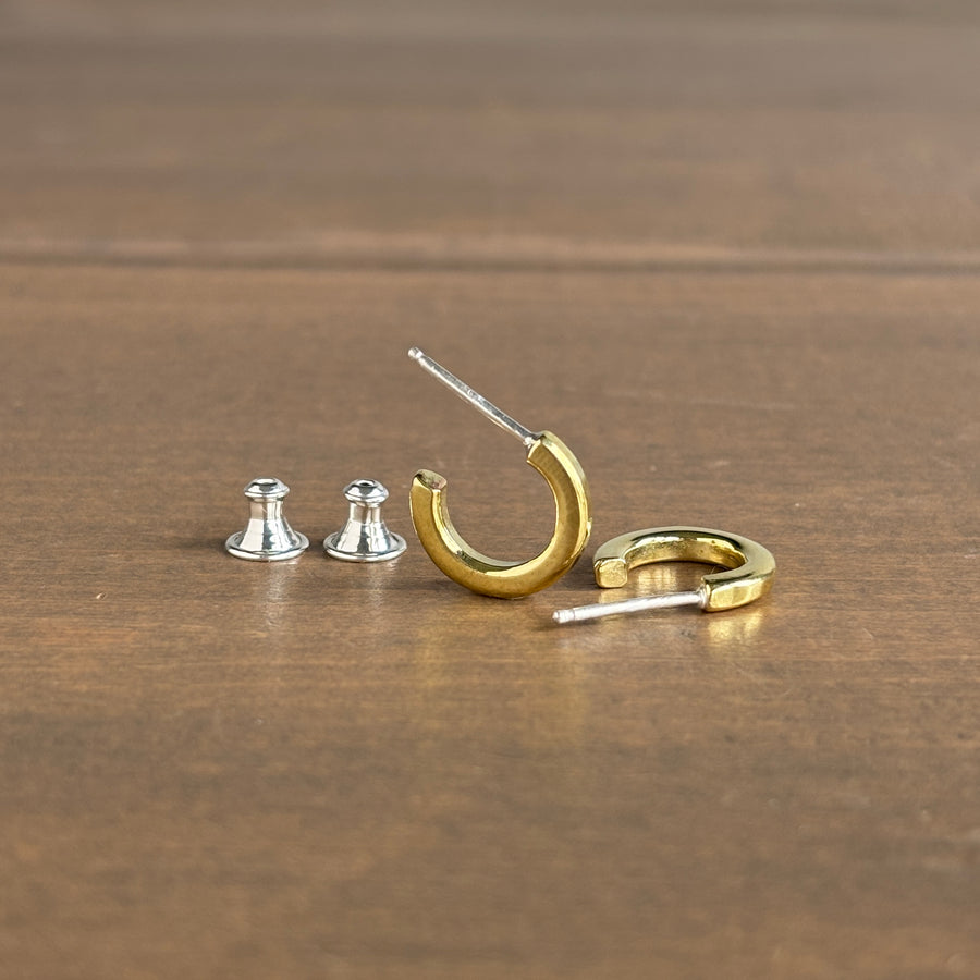 Gold and silver earring components on a wooden surface