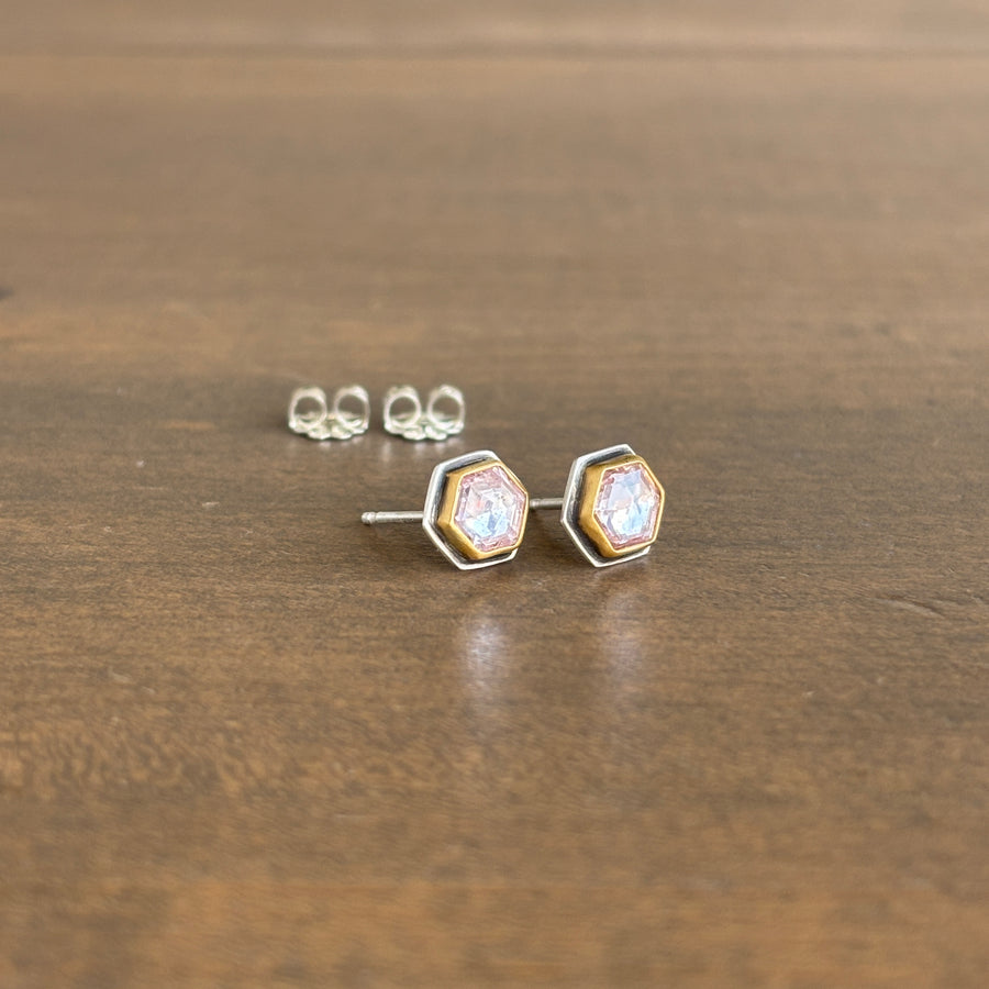 Hexagonal stud earrings on a wooden surface