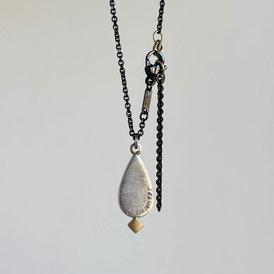 Necklace with a teardrop-shaped pendant on a light gray background