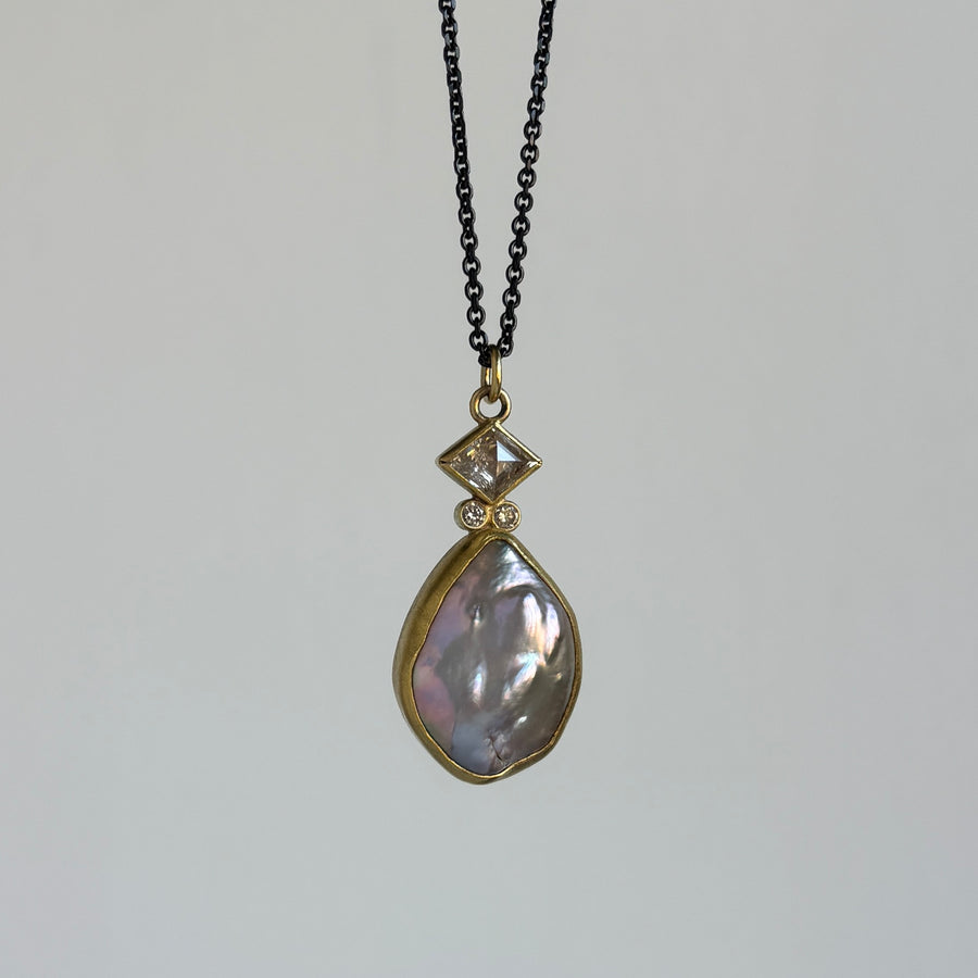 Necklace with a teardrop-shaped pendant on a plain background