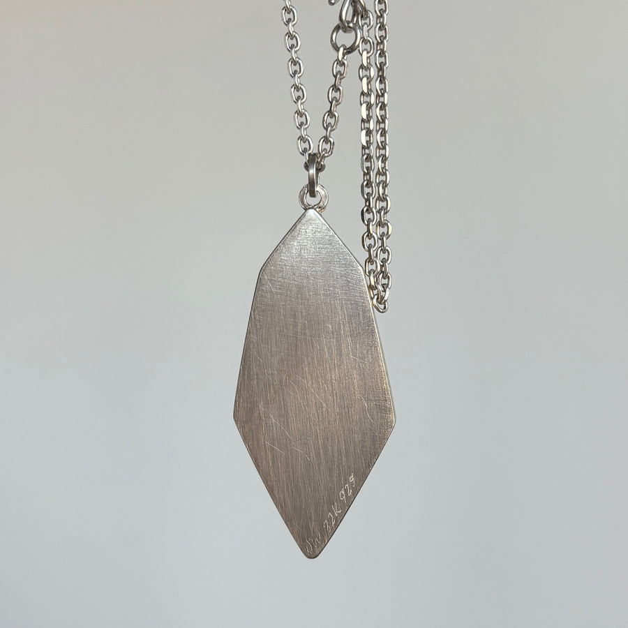 Silver pendant necklace on a light gray background