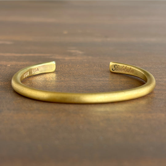 Gold bracelet on a wooden surface