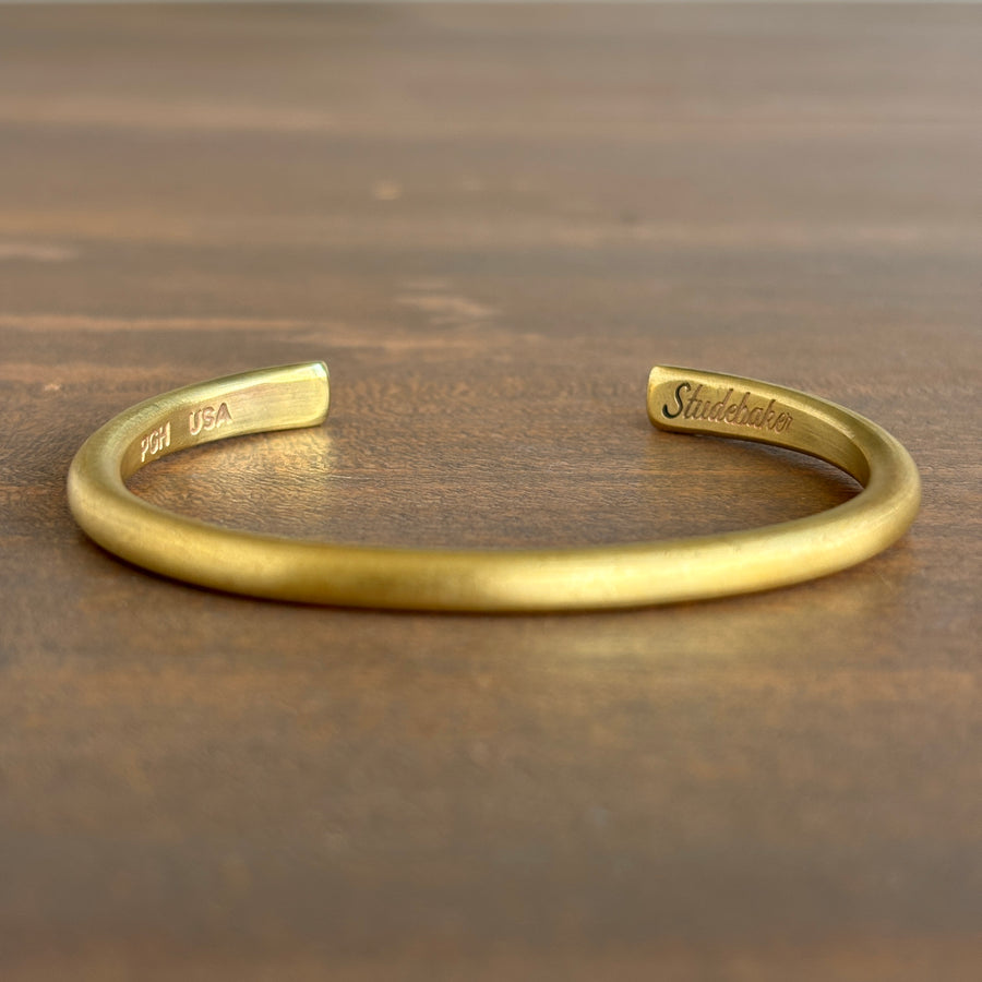 Gold bracelet on a wooden surface