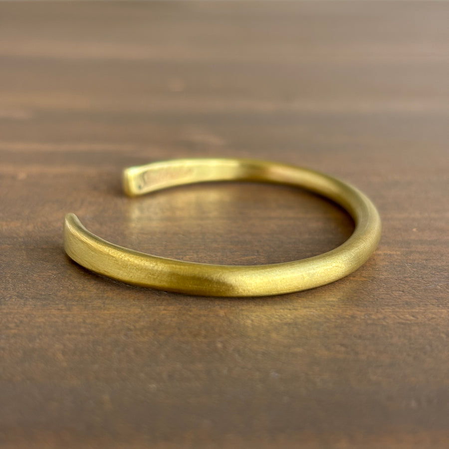 Gold bracelet on a wooden surface