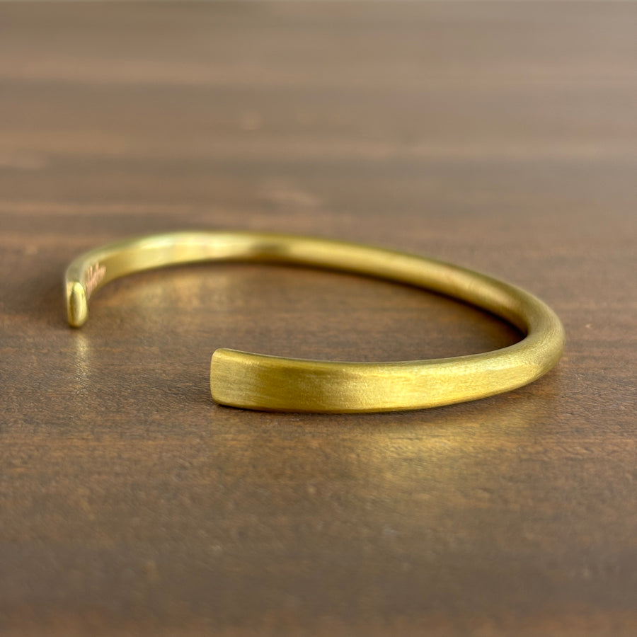 Gold bracelet on a wooden surface