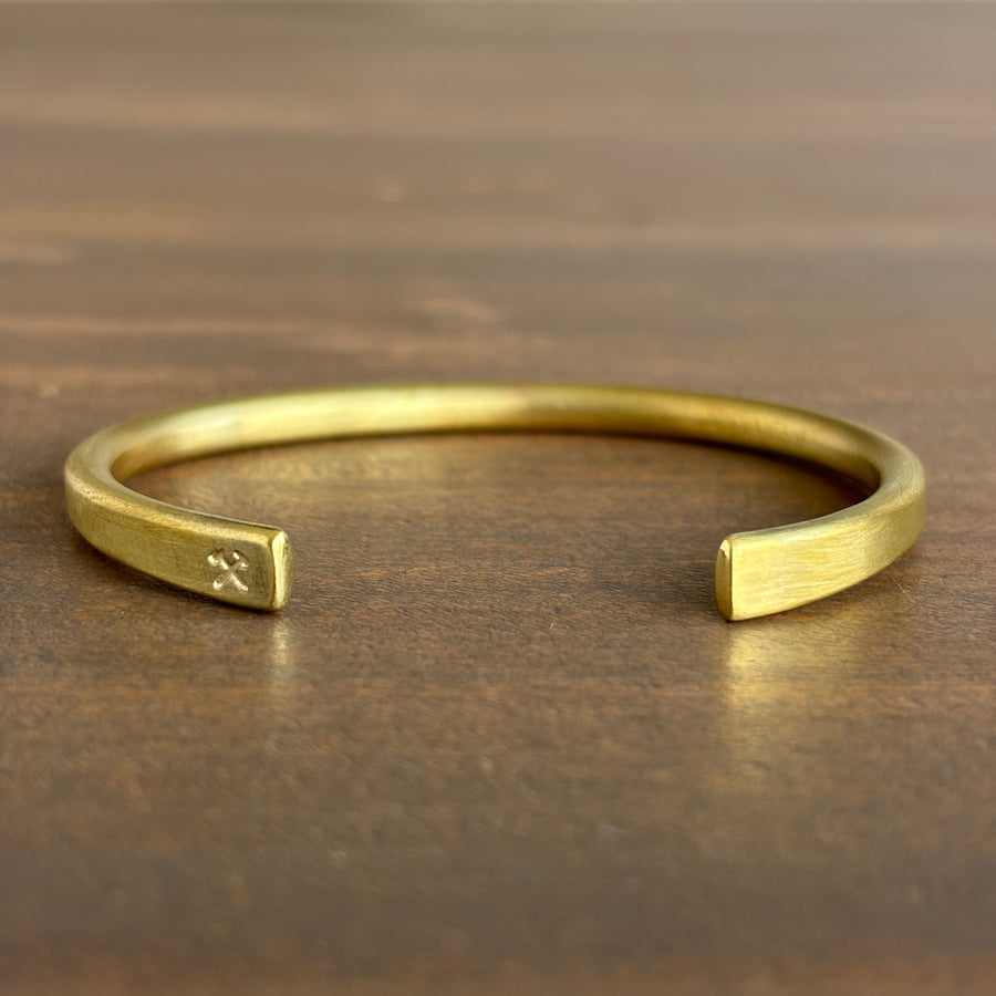 Gold bracelet on a wooden surface