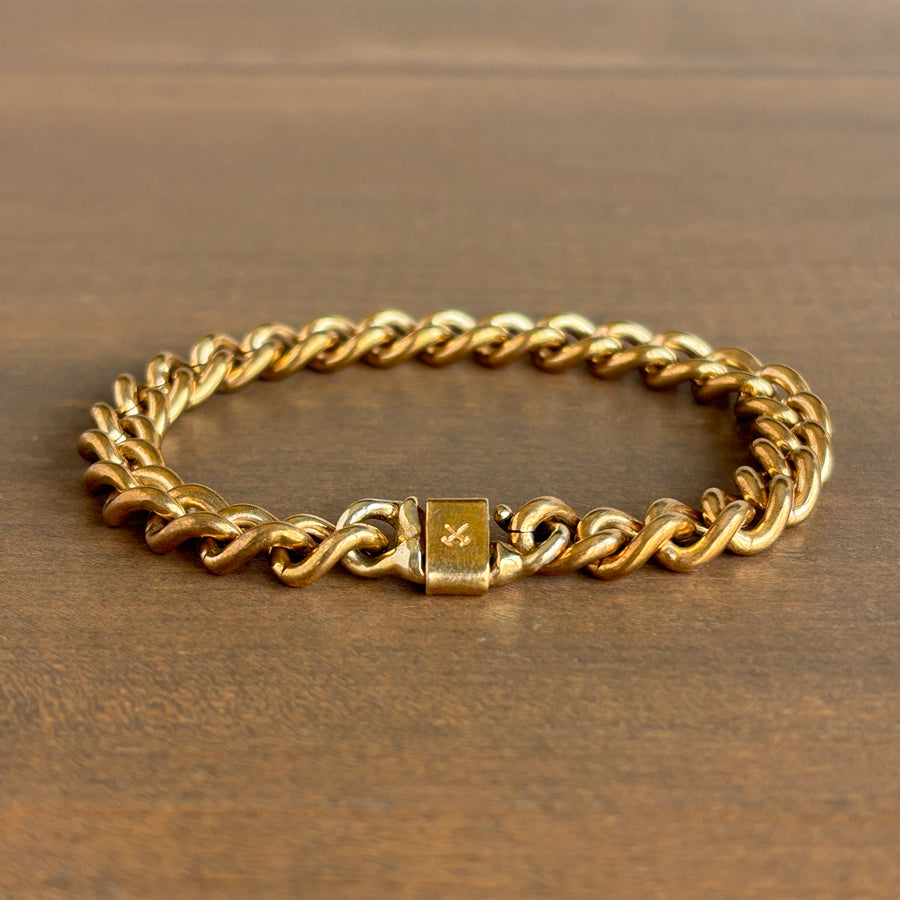 Gold chain bracelet on a wooden surface