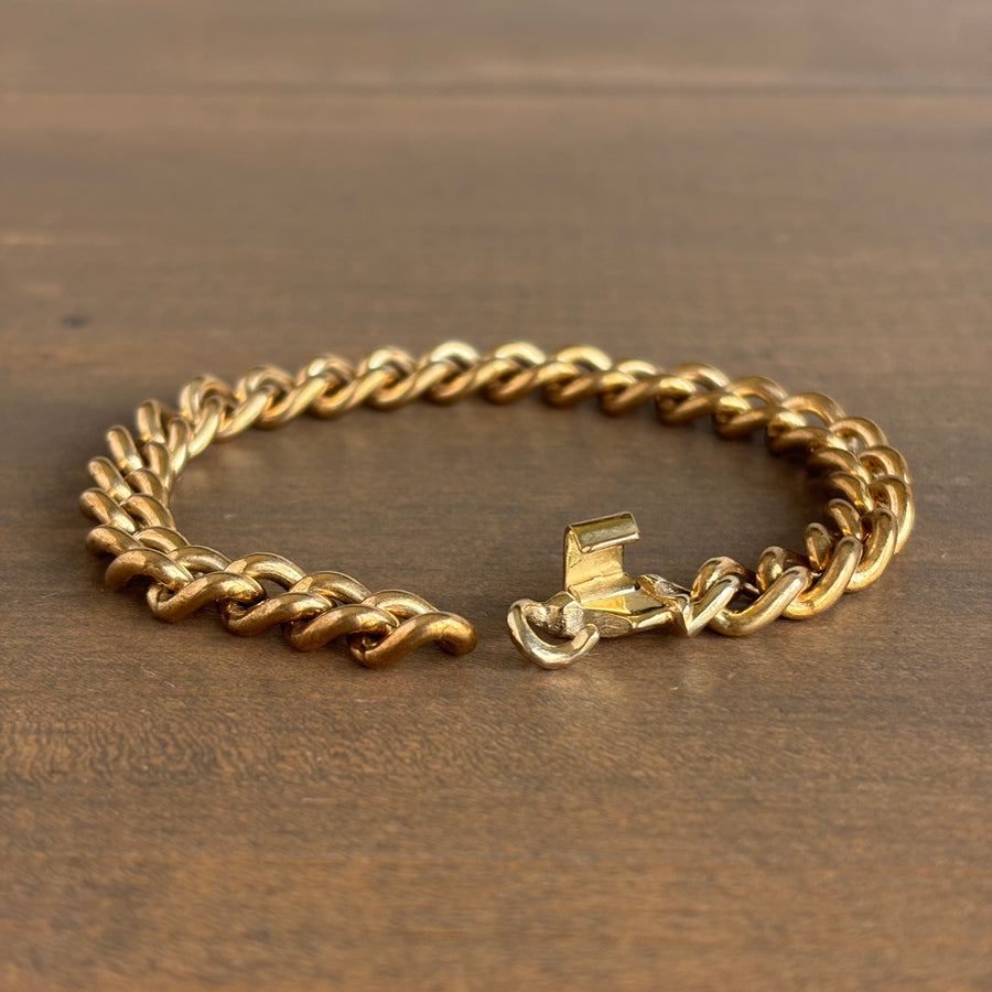 Gold chain bracelet on a wooden surface