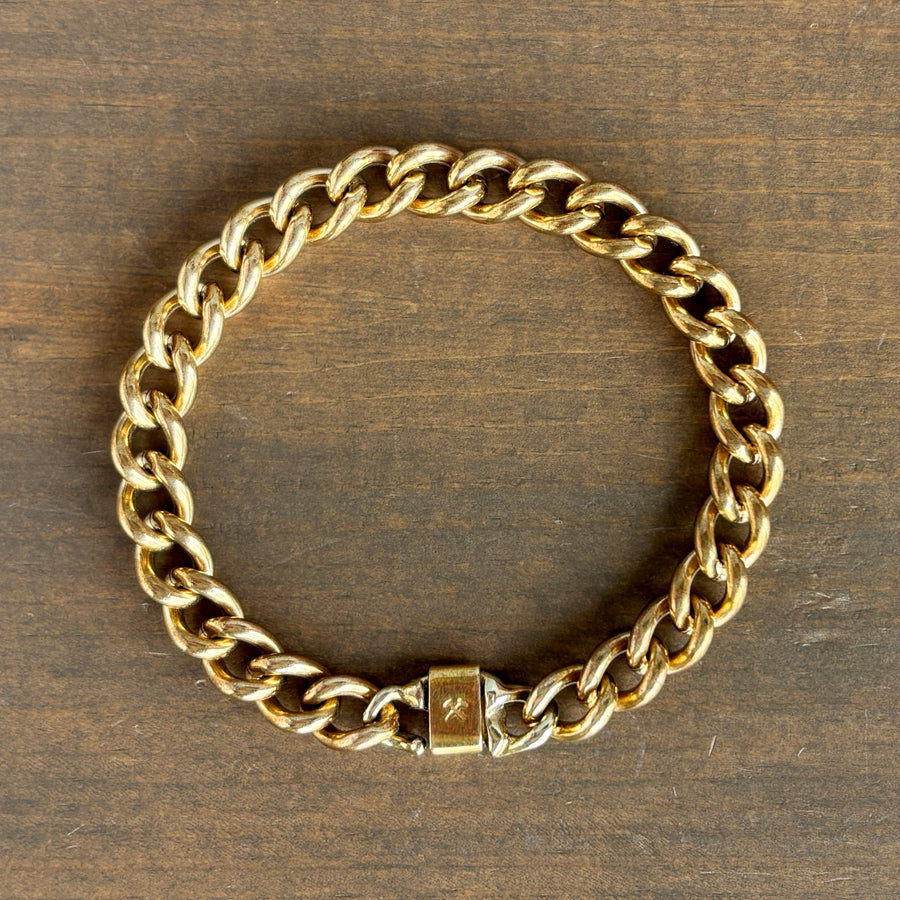 Gold chain bracelet on a wooden surface