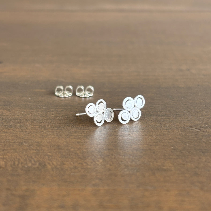 Silver  stud earrings on a wooden surface