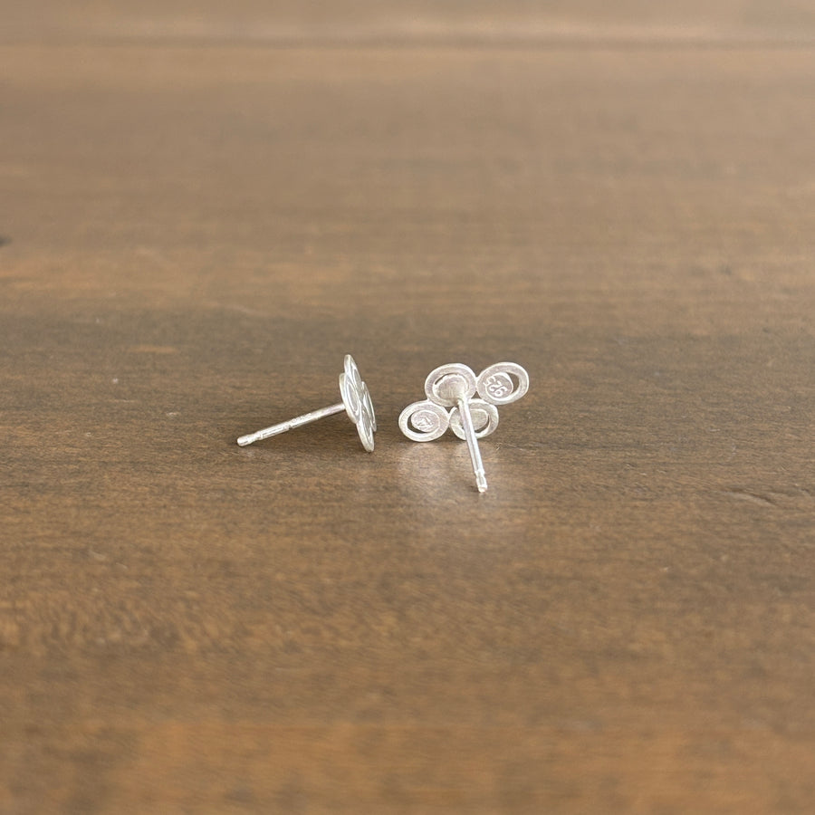Pair of silver earrings on a wooden surface