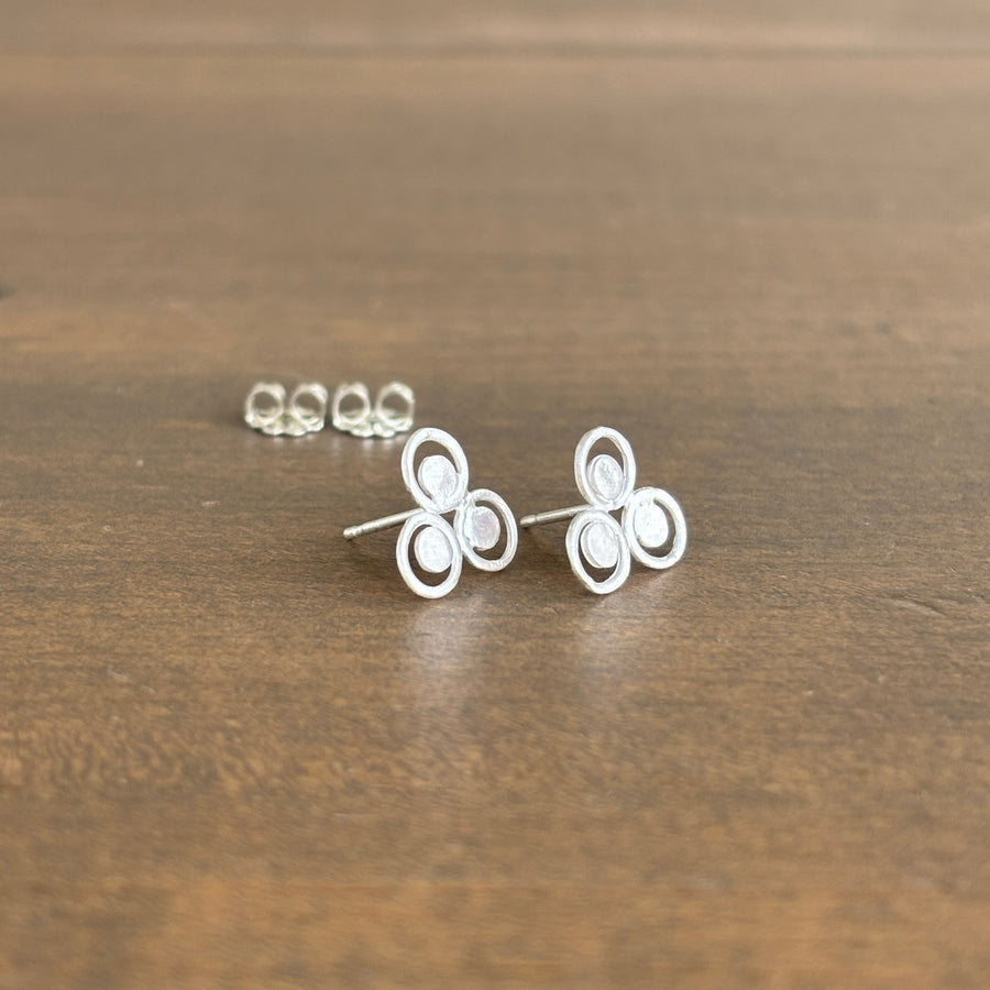 Silver earrings on a wooden surface