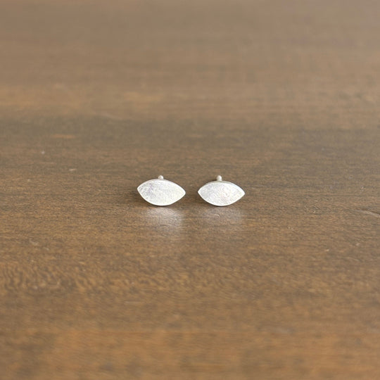 Pair of silver earrings on a wooden surface