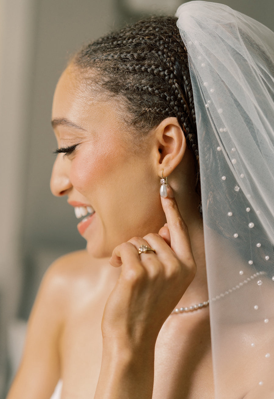 Pearl earrings being worn in the ear